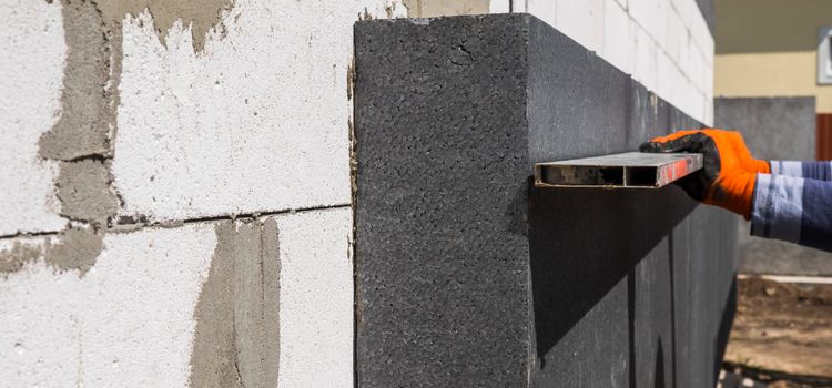 Szakember falra helyez carboland eps grafit szigetelőlapokat - carboland hőszigetelés munka közben